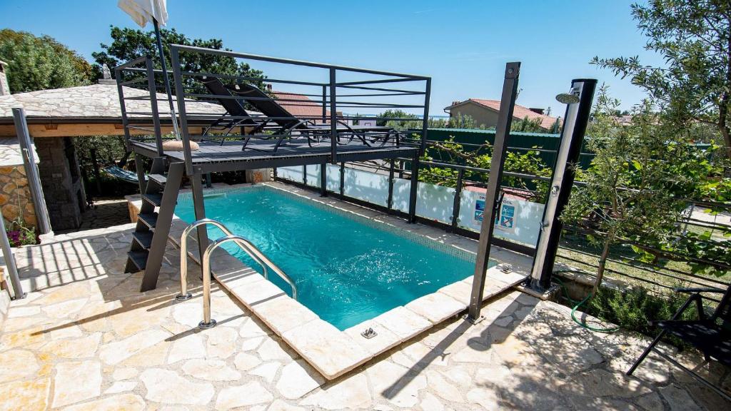 a swimming pool with a metal ladder next to a house at Holiday house Valencan 2 in Mednjan