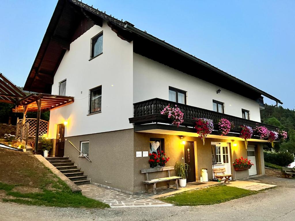 a white house with flowers on the side of it at Haus Sonnsitzer in Sommereben