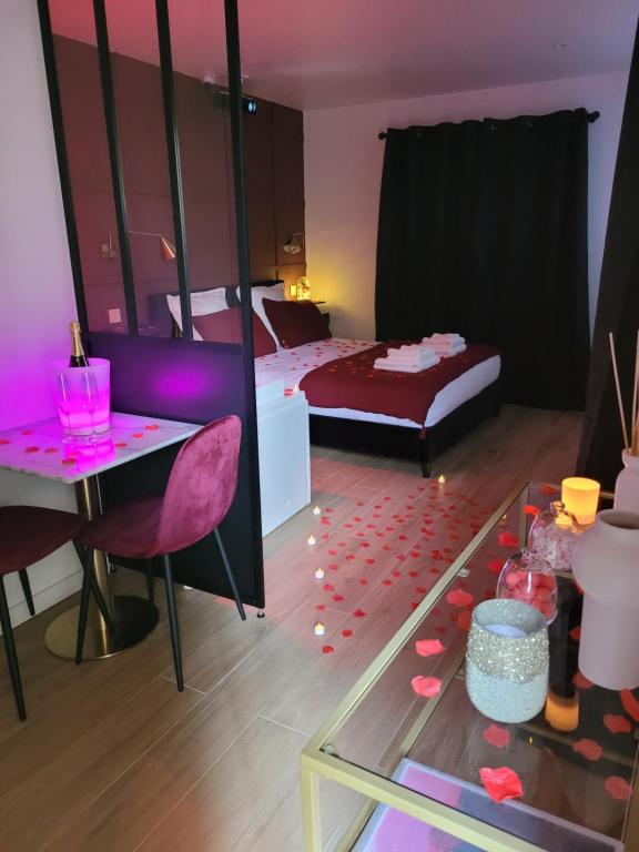 Un dormitorio con una cama y una mesa con corazones en el suelo. en Nuit d'évasion love room avec baignoire balnéothérapie en Toulon