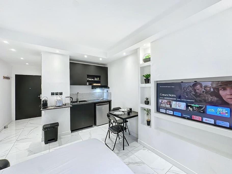 Cette chambre blanche dispose d'une cuisine et d'une télévision murale. dans l'établissement Cosy Appartement, Part Dieu André Philipe, à Lyon