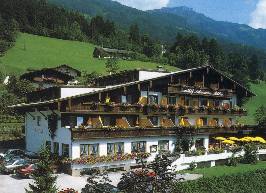 a large building with flowers on the balconies of it at Hotel Schwarzer Adler in Hippach