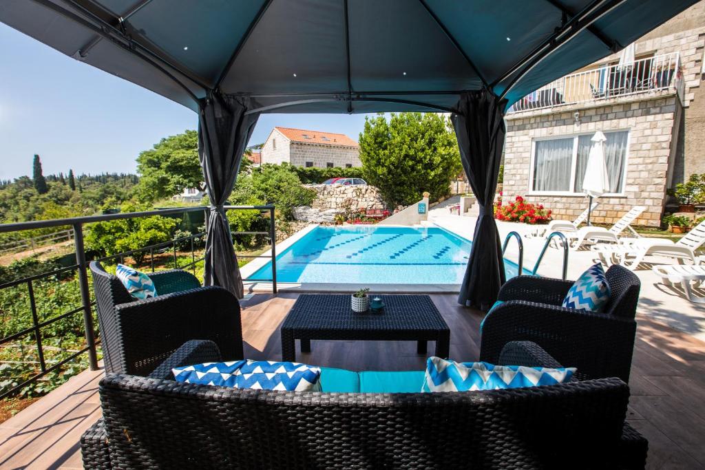 a patio with a table and chairs and a swimming pool at RELAXING Apartments LUCE in Čilipi