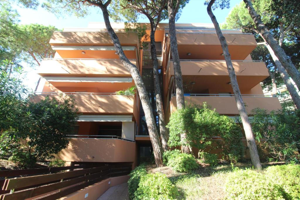 um edifício com árvores em frente em Verdemare Pineta em Lignano Sabbiadoro