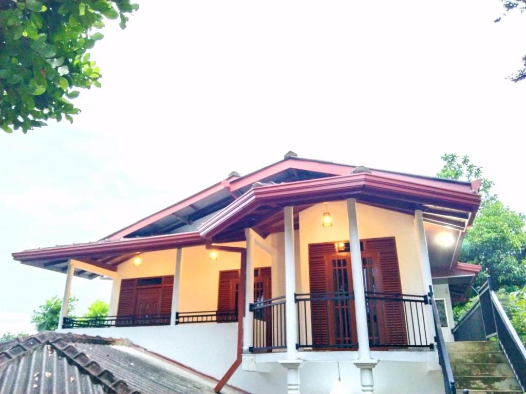 a house with a porch and a balcony at Paradise Villa in Weligama