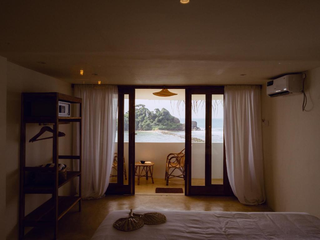 Schlafzimmer mit einem Bett und Meerblick in der Unterkunft Blue Waves Surf Hotel Sri Lanka in Ahangama