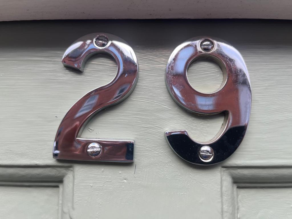 a metal number on the side of a garage door at Eurovilla in Belfast