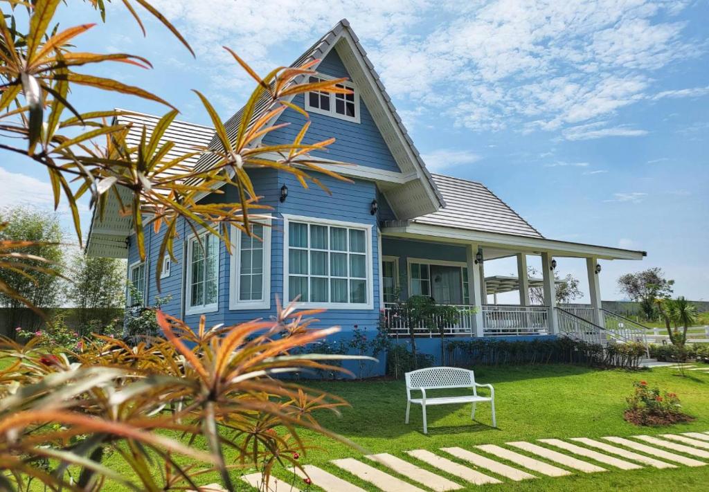 a blue house with a white chair in the yard at Hamilton House in Ban Sathani Bandai Ma