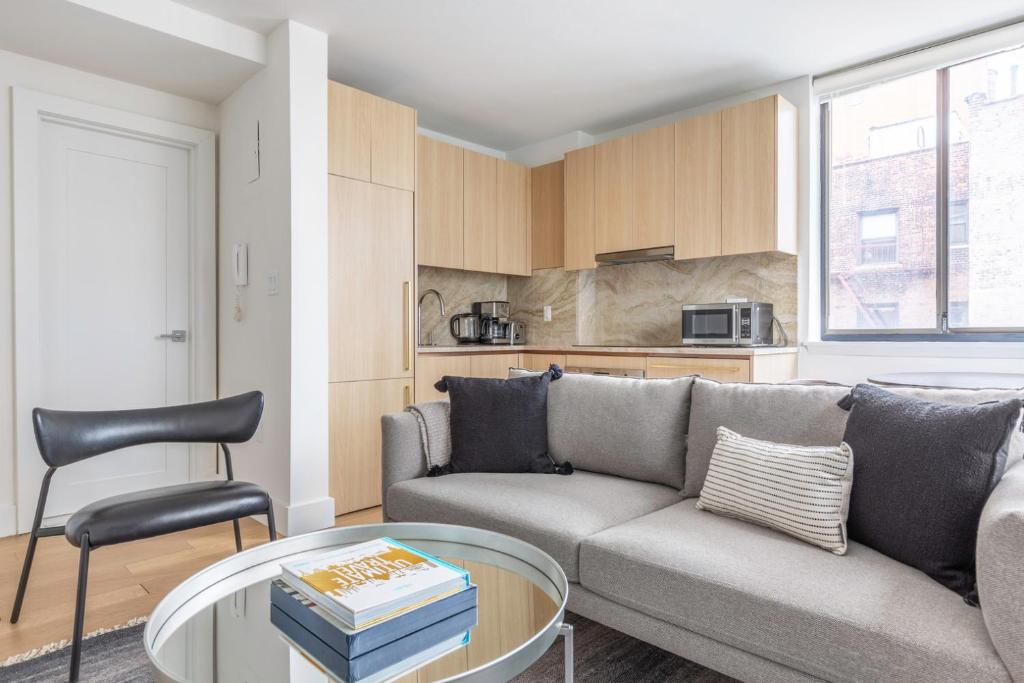 een woonkamer met een bank en een tafel bij Chelsea 1br w doorman elevator nr High Line NYC-601 in New York