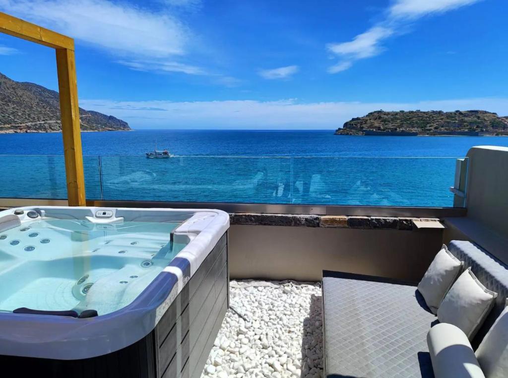 a jacuzzi tub with a view of the ocean at Casa di Plaka in Elounda