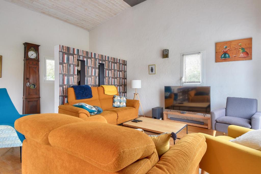 un salon avec deux canapés et une télévision dans l'établissement Maison moderne avec jardin pour 12 personnes, à Saint-Jean-de-Monts