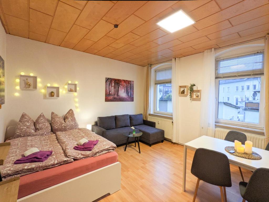 a bedroom with a bed and a couch and a table at R2 - Urlaubsmagie - 5 Fussminuten zur Elbe, Pool in Rathmannsdorf