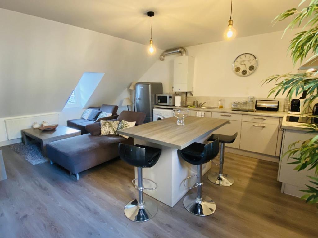 uma cozinha e sala de estar com uma mesa e um sofá em Le Pigeonnier em Rodez