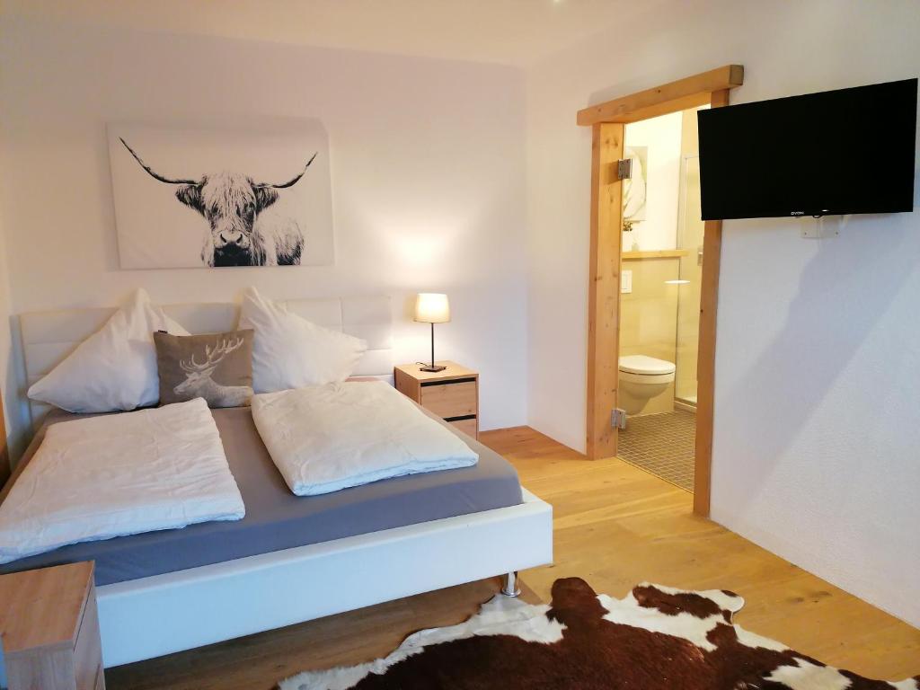 1 dormitorio con 1 cama con una foto de vaca en la pared en Haus Miriam en Mieming