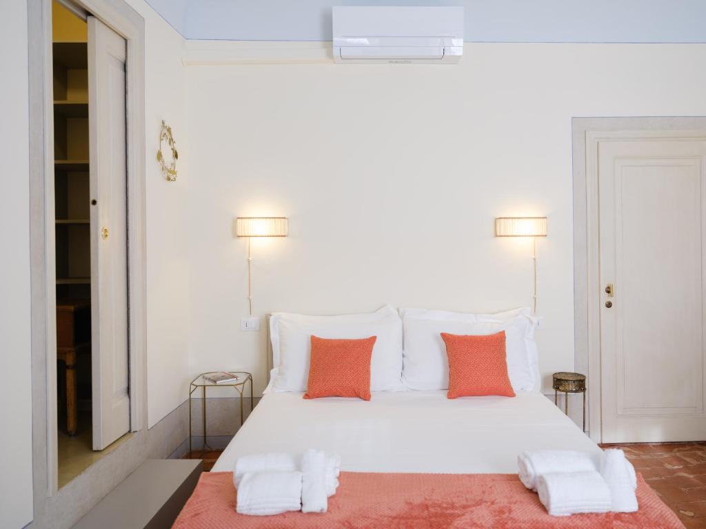 - une chambre avec un lit blanc et des oreillers orange dans l'établissement La Mezzina - Unique design and crafted lifestyle, à Florence