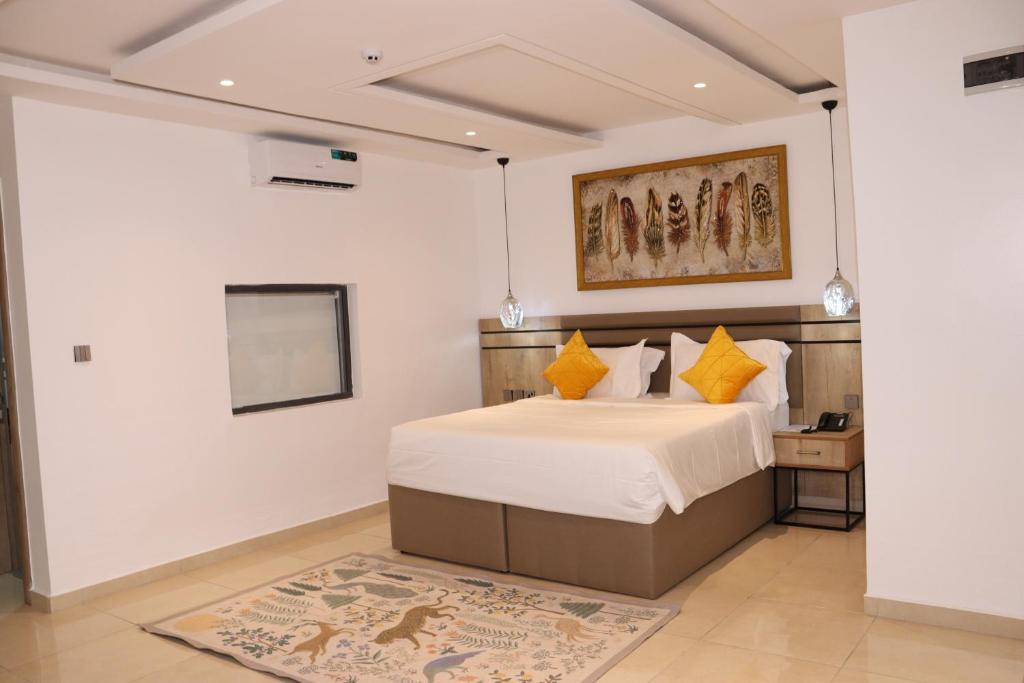 a bedroom with a bed and a painting on the wall at Top7 Orlando in Abuja