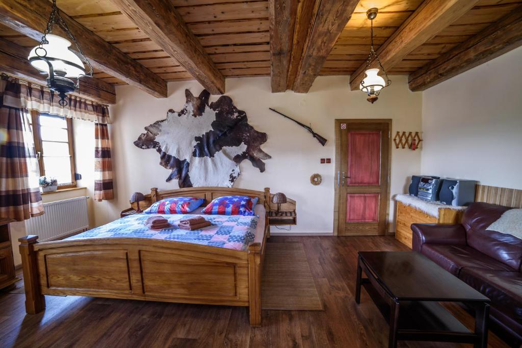 ein Schlafzimmer mit einem Bett und einem Sofa in der Unterkunft Steak Restaurant Penzion Country Saloon in Klatovy