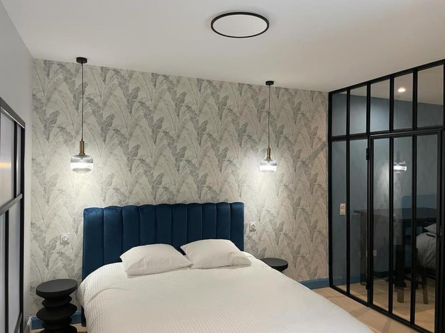 - une chambre avec un lit bleu et 2 oreillers dans l'établissement Appartement pour 1à2 personnes#2, à Lyon