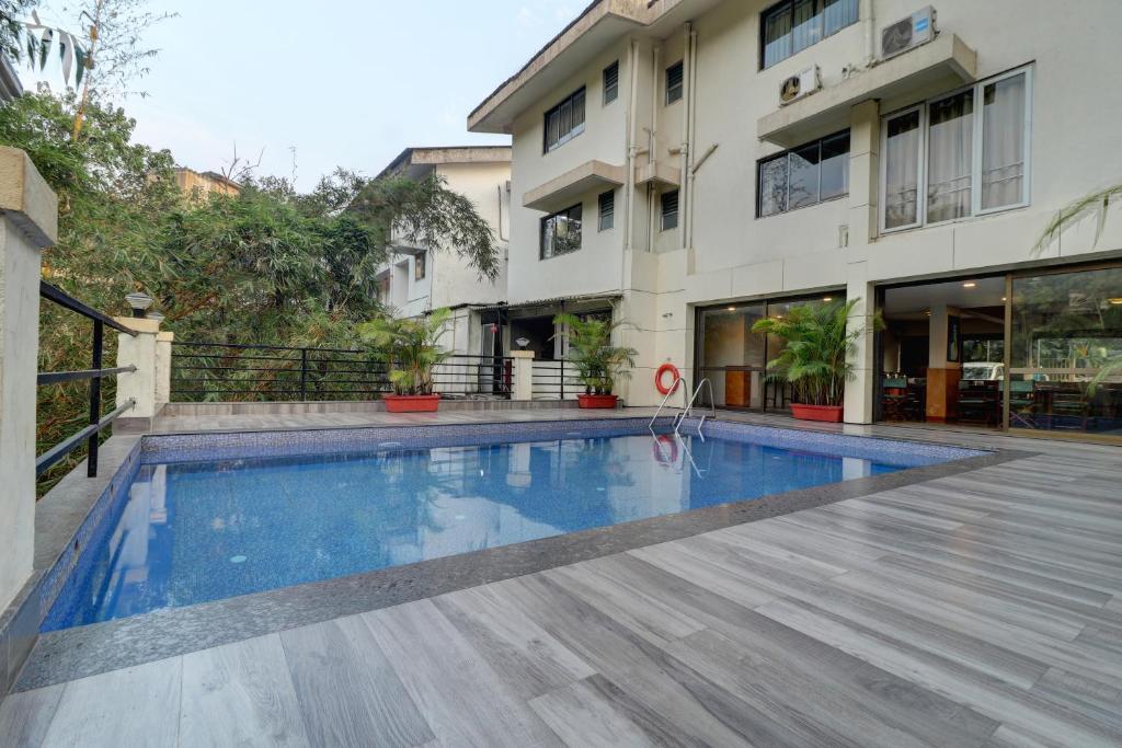 a swimming pool in front of a building at Amazinn Villa in Lonavala