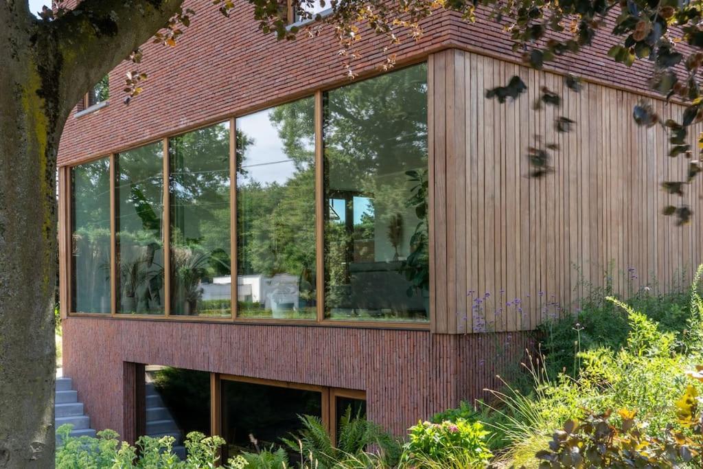 a glass house with a brick exterior at Sweet Valley View - Architectenwoning in Zutendaal