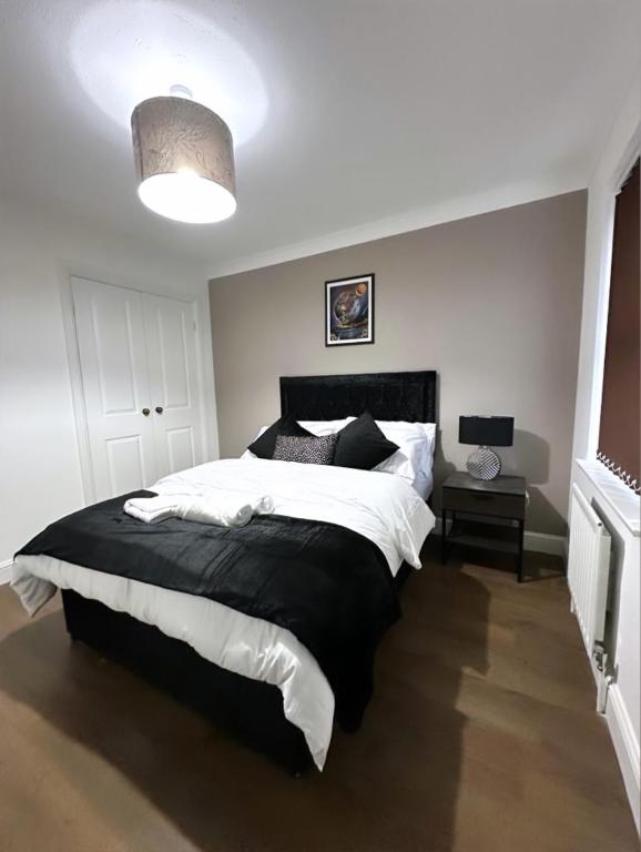 a bedroom with a black and white bed and a lamp at Md Stays in London