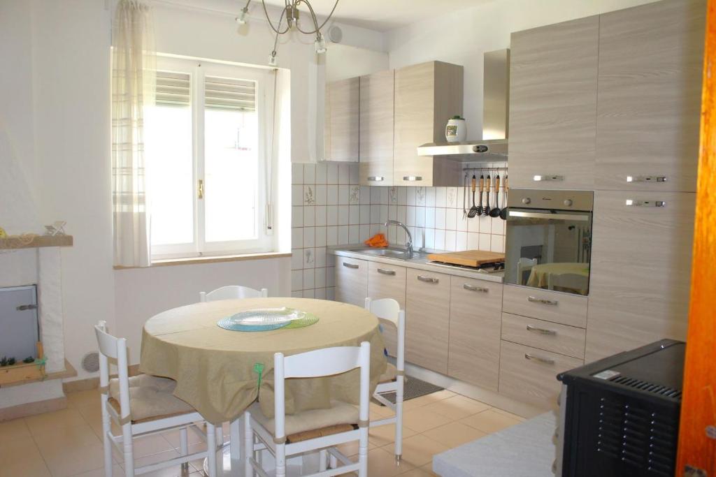 een keuken met een tafel en stoelen bij GIAMPIERO ampio appartamento con 4 camere e 2 bagni in Sirolo