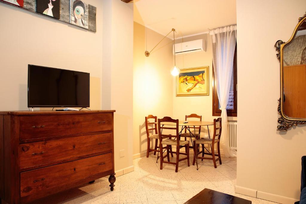 a living room with a television and a dining room table at Saint Charles Apartment in Bologna