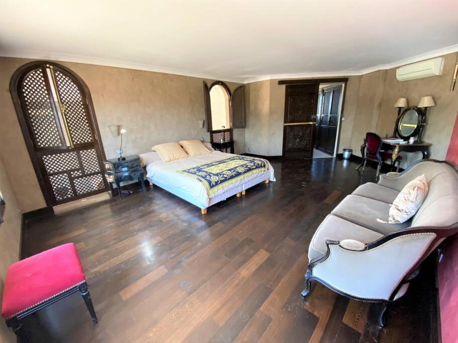 une chambre avec un lit et un canapé dans une pièce dans l'établissement Chambre Ebene, Riad 9 Couple only au village naturiste, au Cap d'Agde