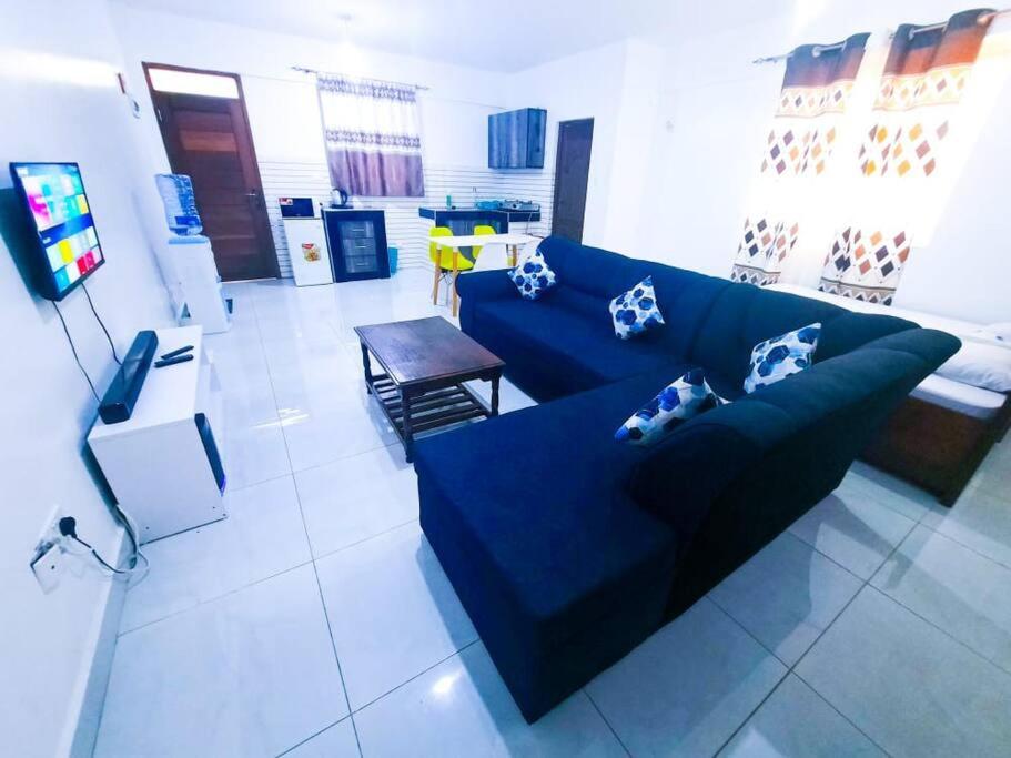 a living room with a blue couch and a table at 1 bedroom with 2 beds, Mombasa Kisimani, Nyali in Mombasa