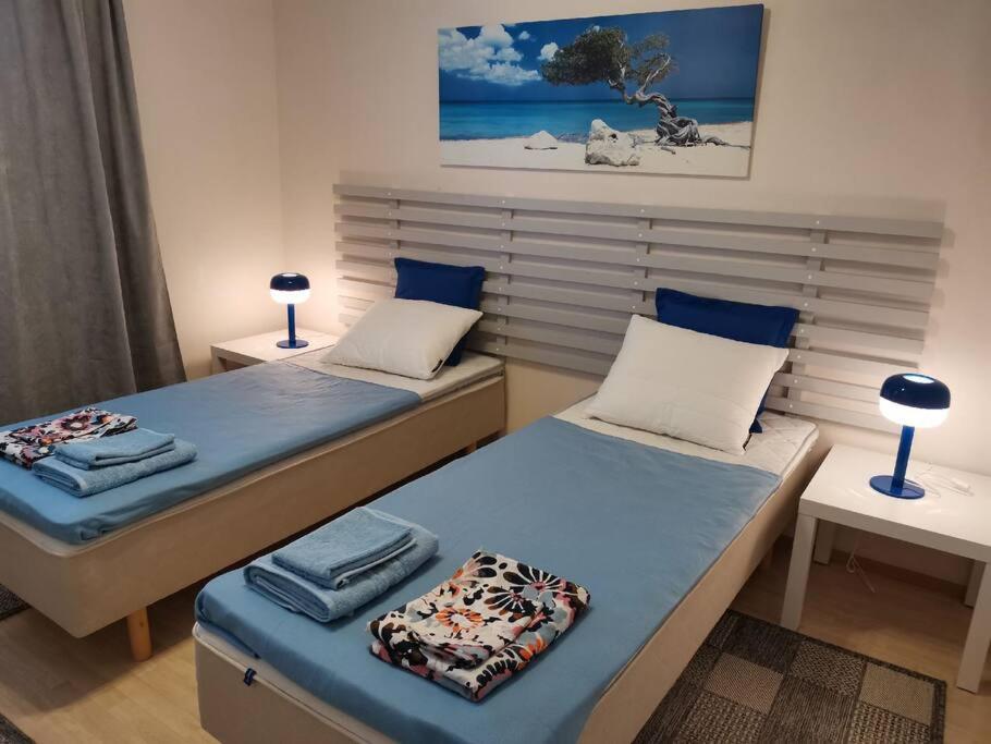2 camas individuales en una habitación con 2 lámparas en Sea Apart Velhontie, en Kotka