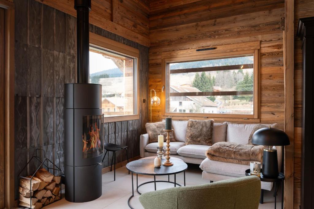a living room with a fireplace in a cabin at Chalet Mayen, luxueux et intimiste in Ban-sur-Meurthe-Clefcy