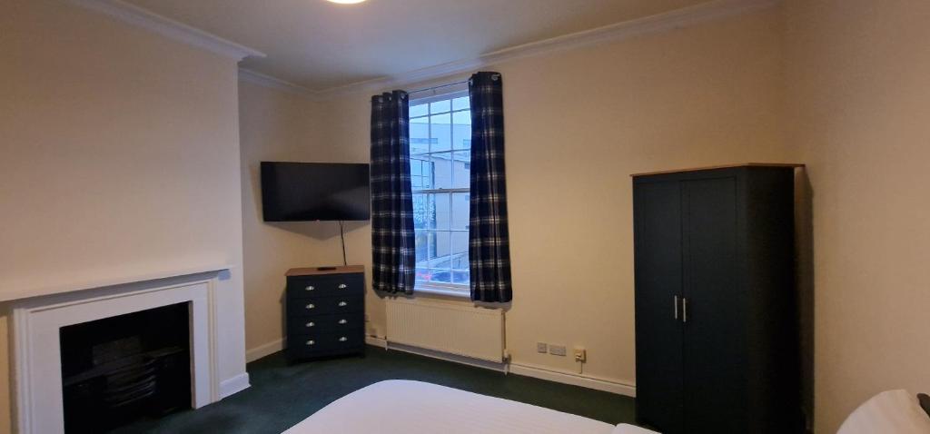 a bedroom with a bed and a fireplace and a window at ROOMS in WAKEFIELD CITY CENTRE in Wakefield