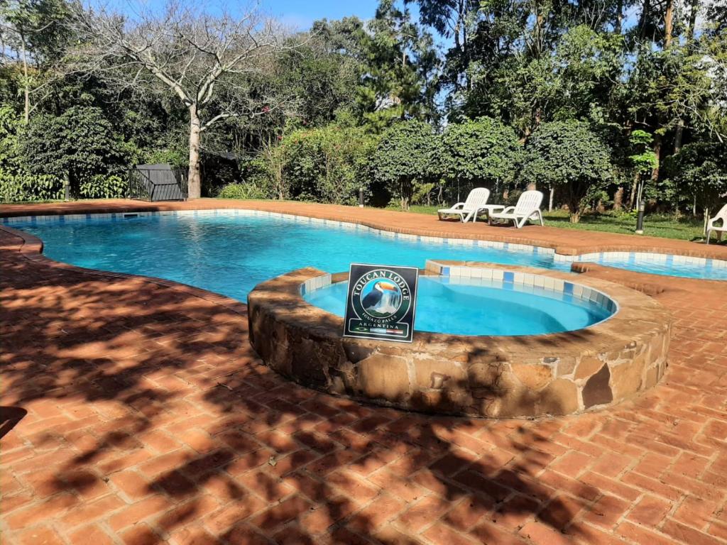 uma piscina com uma pedra à volta em Toucan Lodge em Puerto Iguazú