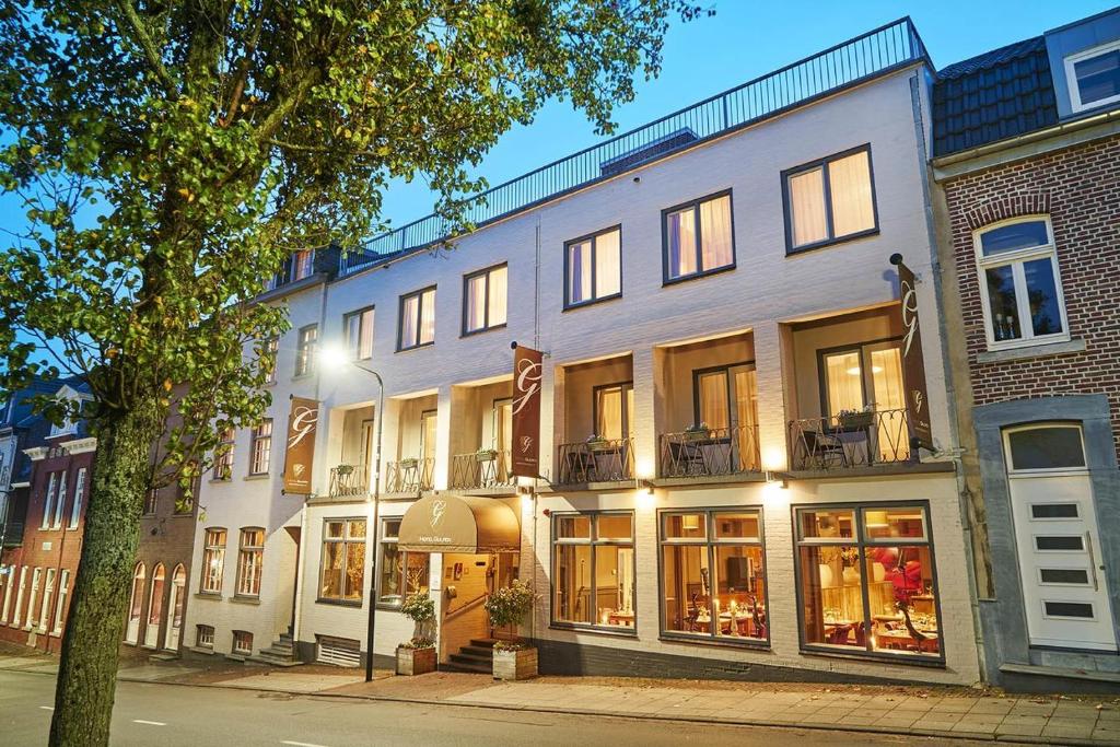 - un bâtiment dans une rue de la ville avec un éclairage de rue dans l'établissement Hotel Courage Gulpen-Wittem, à Gulpen
