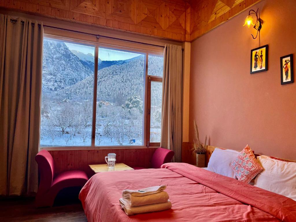 a bedroom with a bed and a large window at Flüstern Hostel and Café in Nagar