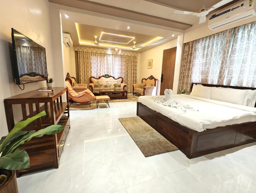 a bedroom with a large bed and a living room at The Sky Imperial Sethji Ni Wadi in Indore
