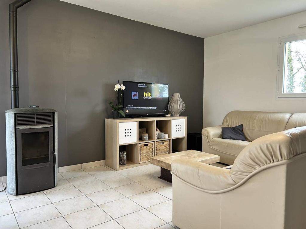 - un salon avec un canapé et une télévision dans l'établissement 956 - Maison 6p, à 15min du Val-André et d'Erquy., à Hénansal