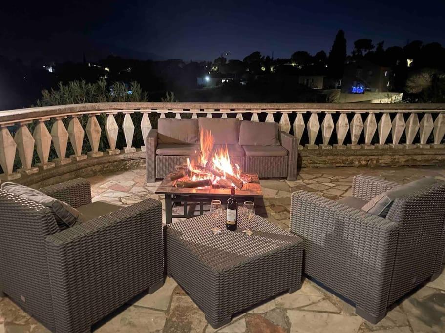 a fire pit on a patio with wicker furniture at Logement très chaleureux à Marseille in Marseille