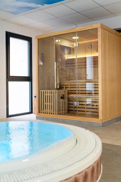 a large swimming pool with a tub in a room at Kyriad Prestige Residence & Spa Cabourg-Dives-sur-Mer in Dives-sur-Mer