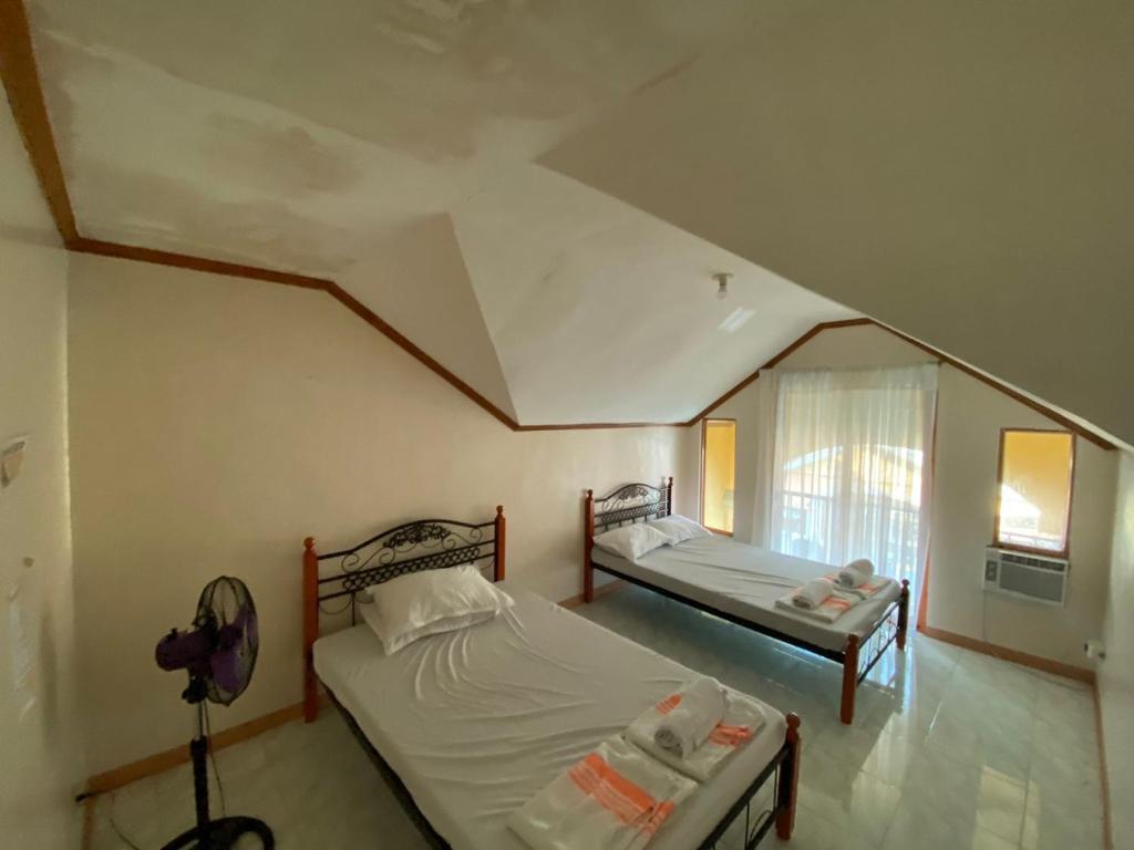 a bedroom with two beds and a window at The Orange House - Vigan Villa in Vigan
