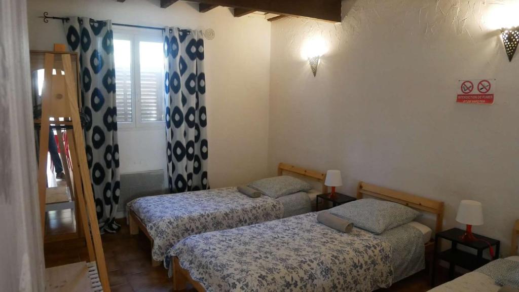 een kamer met 3 bedden en een raam bij Mas Maurane - Le Bougainvillier aux portes d'ARLES in Tarascon