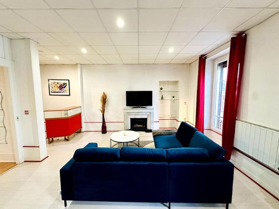 un salon avec un canapé bleu et une cheminée dans l'établissement Spacieux T2 en hyper centre, à Aix-les-Bains