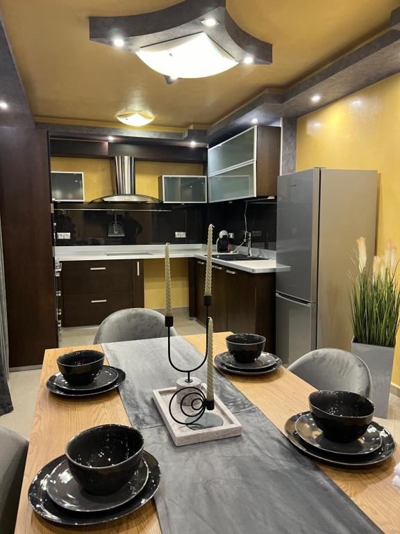 una cocina con una mesa con tazones. en Апартамент БМ en Vratsa