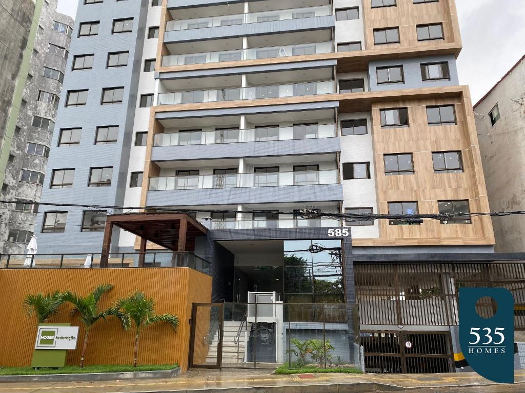 um edifício de apartamentos alto com uma placa em frente em Lindo Apartamento Quarto e Sala em Salvador em Salvador