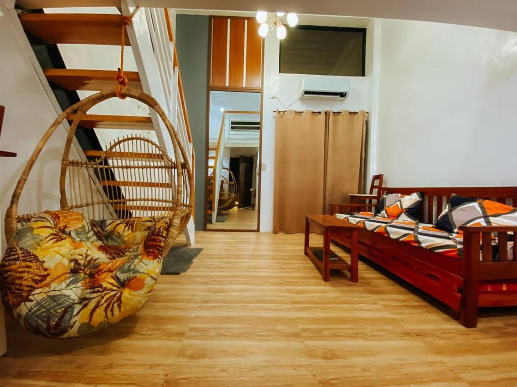 een kamer met 2 bedden en een schommel bij The River House - Loft Units in Vigan