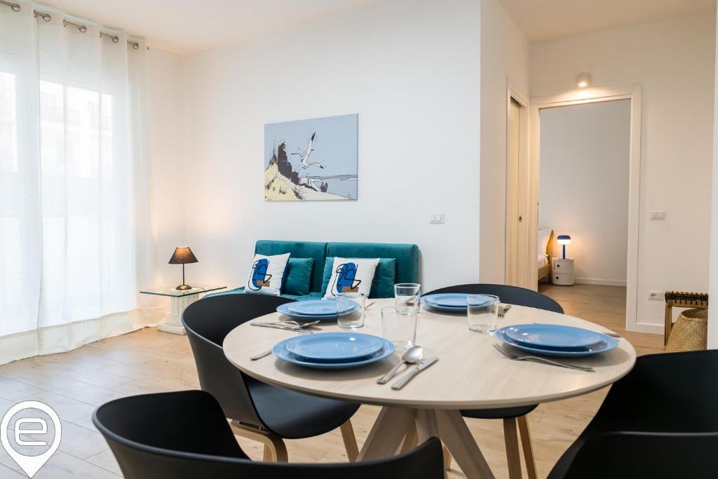 uma sala de jantar com uma mesa com pratos azuis em Foscolo City Retreat em Alghero