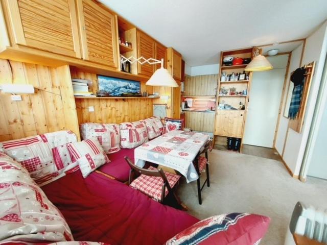 Cette chambre comprend un canapé, une table et des chaises. dans l'établissement Plagne village 100% SKI aux pieds, à La Plagne Tarentaise
