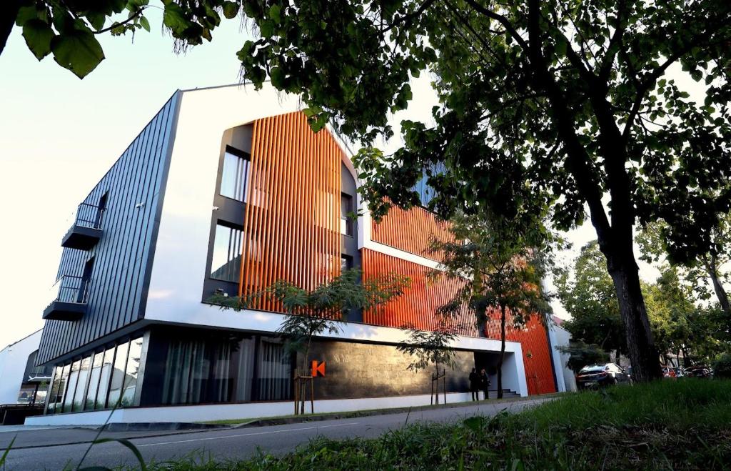 a building with an orange and white facade at Casa Calfelor Kolping Timișoara in Timişoara