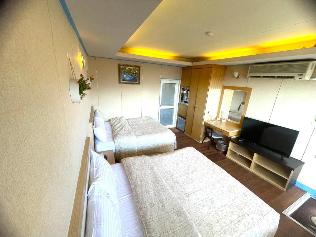 仁愛鄉的住宿－清境以馬內利休閒景觀渡假村，酒店客房设有两张床和电视。