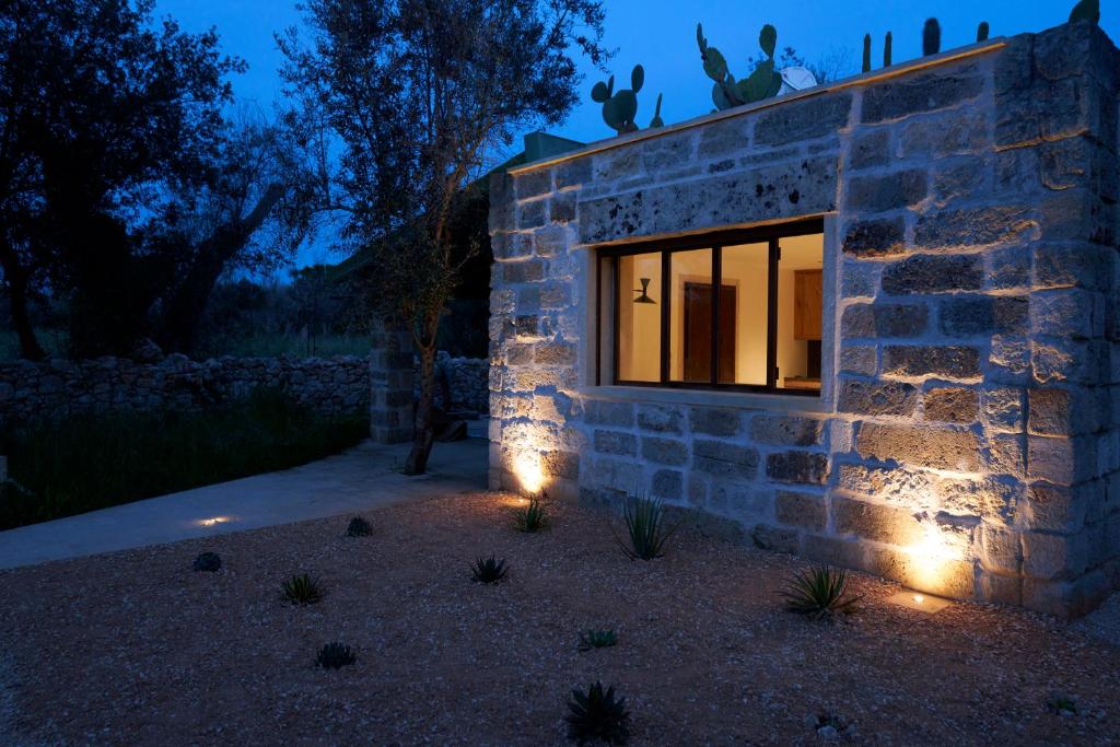 ein Fenster in einem Steingebäude mit Beleuchtung in der Unterkunft Il Cubetto- a cute mini house in olive grove in Surano