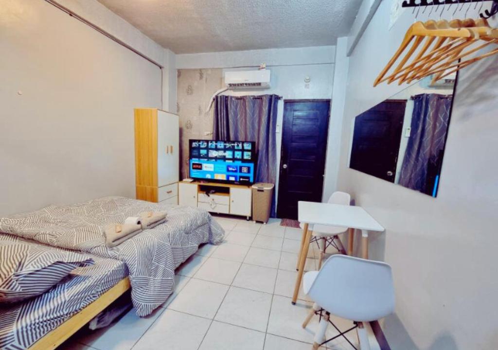 a bedroom with a bed and a tv in it at Small Apartment Near SM North Project 7 in Manila